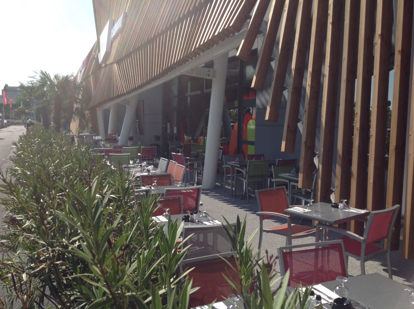 La terrasse du Dôme le long de la façade en lattes de bois, entre les lauriers